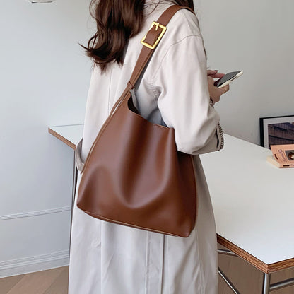 Sac Margot marron porté à l’épaule avec une tenue claire