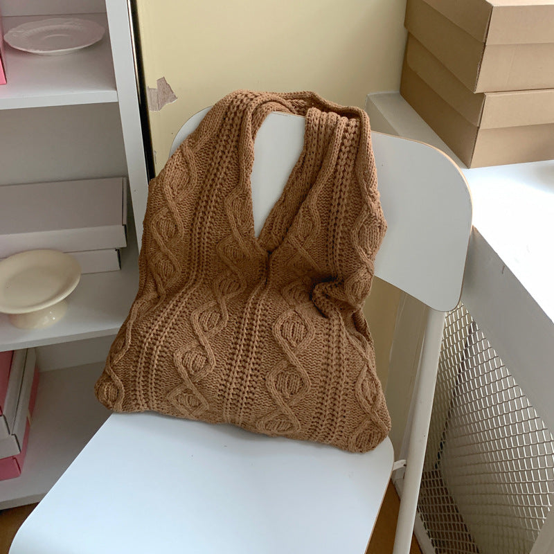 Cabas Juliette café en maille torsadée posé sur une chaise
